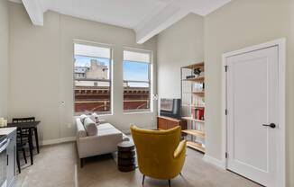 a living room with a couch and a chair and a window