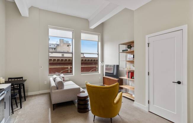 a living room with a couch and a chair and a window