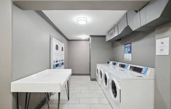 a laundry room with a row of washing machines