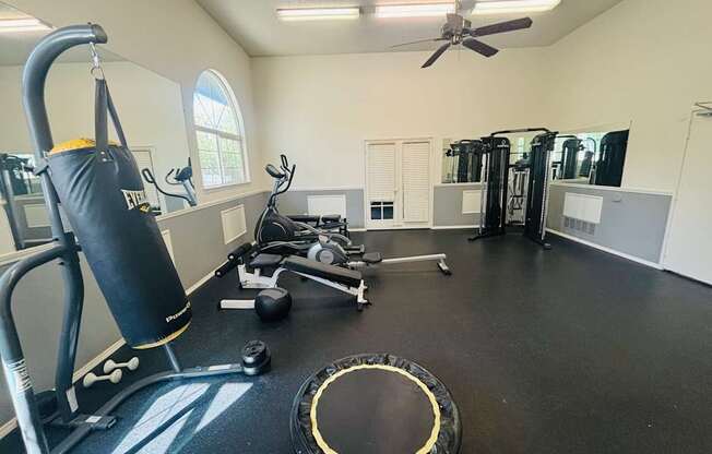 A gym with a punching bag, exercise bikes, and other equipment.