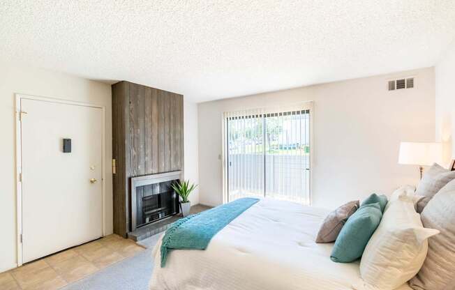 A bedroom with a large bed and a fireplace.