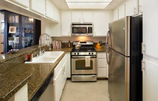 Apartment kitchen with built-in cabinets and stainless steel appliances