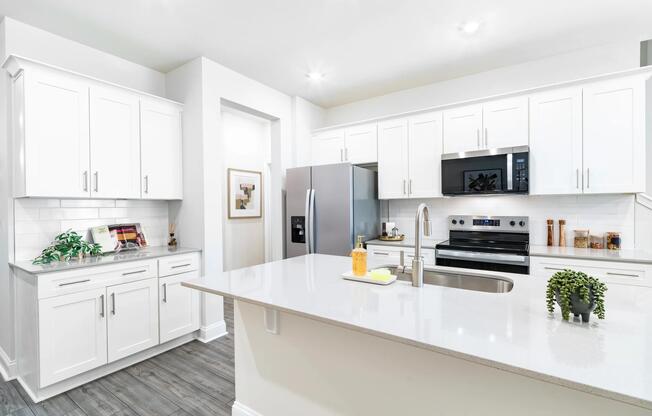 Spacious kitchens feature large quartz islands, white shaker-style cabinetry, stainless steel appliances, and ample storage designed for everyday cooking, dining, and entertaining.