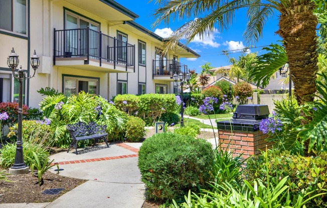 a courtyard with benches and plants in front of an apartment building at Camino de Oro Apartments, Torrance, CA, 90505
