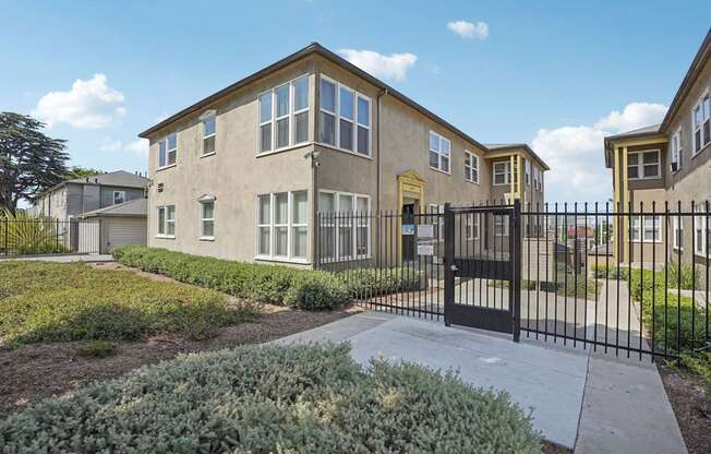 A row of houses with a black gate in front.