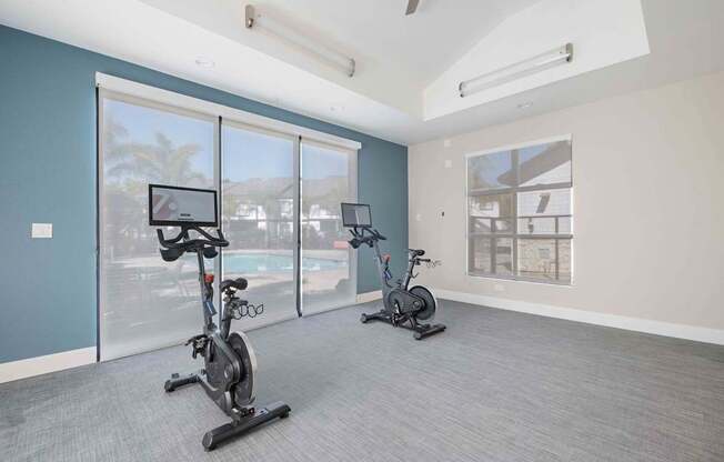A room with exercise bikes and a view of the outside.