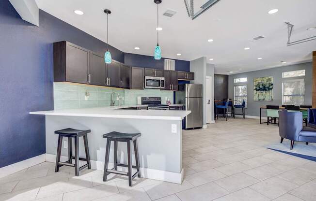 A kitchen with a white counter and bar stools.