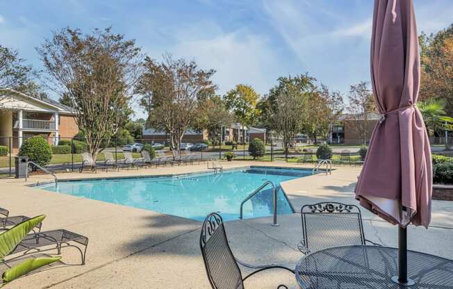 a swimming pool with tables and chairs and a umbrella