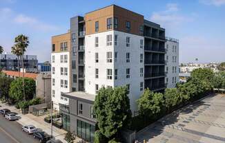 A modern multi-story building with a parking lot in front at Skylar At Sunset Apartments, California, 90027