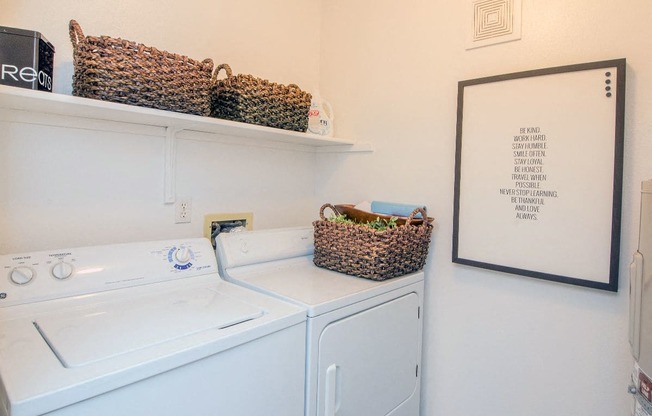 a white washer and dryer in a laundry room with baskets