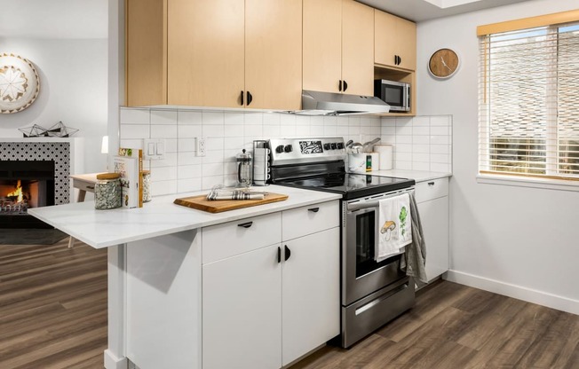 a kitchen with white cabinets and a stove and a fireplace