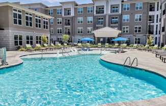 a swimming pool with an apartment building in the background