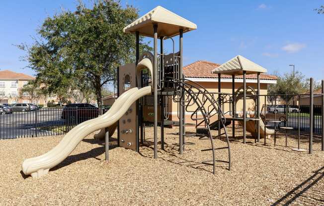 Rapallo Apartments community playground equipped with slide and jungle gym.
