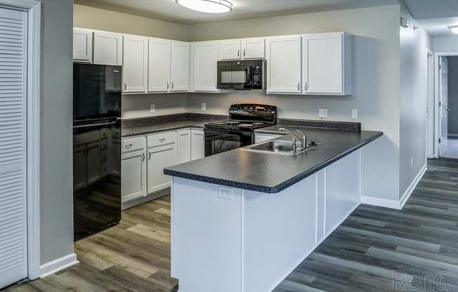 a kitchen with white cabinets and stainless steel counter tops