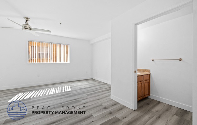 a living room with white walls and wood floors and a closet