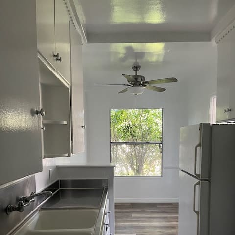 a kitchen with two sinks and a large fan