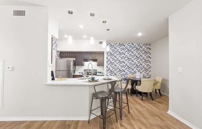a kitchen with a bar and a dining area with stools