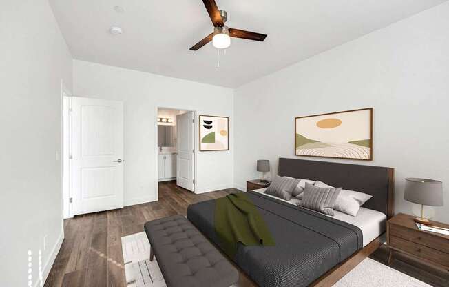 A bedroom with a bed, a ceiling fan, and a painting on the wall.