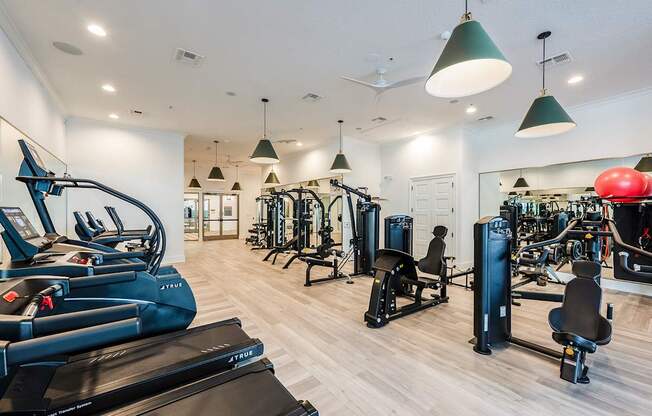 A gym with treadmills, weights, and exercise equipment.