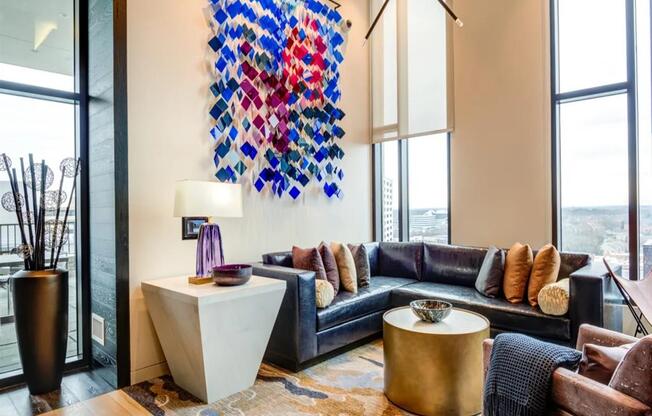 a living room with a black couch and a large colorful painting on the wall at The Boro, Tysons, VA
