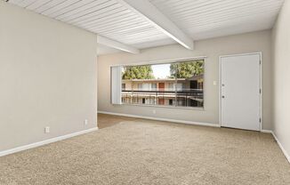 A room with a carpeted floor and a large window.