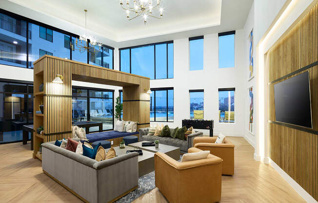 A modern living room with a large sectional sofa and a chandelier.