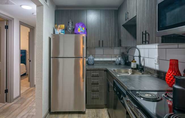 Nashville Apartments - The Canvas - Modern Kitchen with Soft-Close Wood-Inspired Cabinets, Stainless-Steel Appliances, and Hardwood-Inspired Flooring