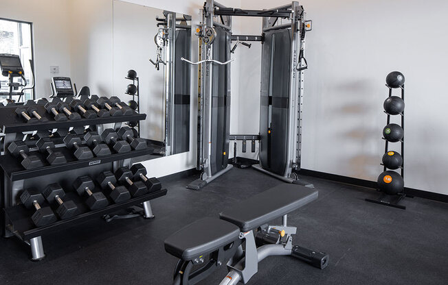 a fully equipped fitness room with weights and cardio equipment at The Landing at 1001 NP, Fargo, ND 58102