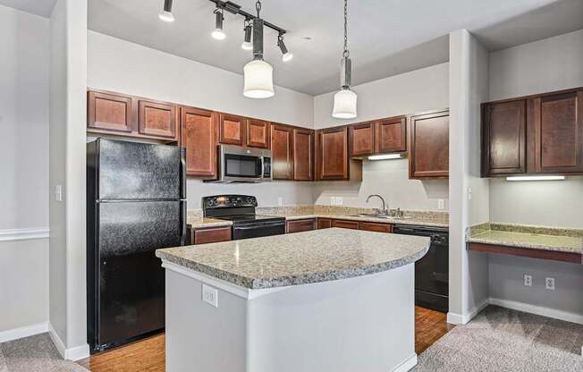 A kitchen with a black fridge and brown cabinets.