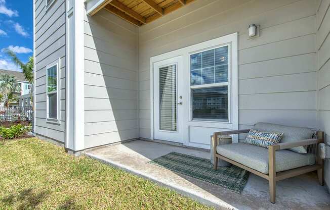 A house with a white door and a bench outside.