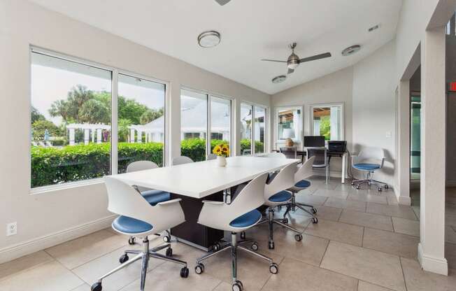 a conference room with a white table and chairs and windows