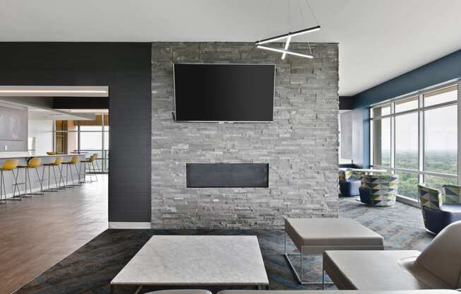 a living room with a stone fireplace and a tv on the wall