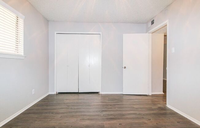 an empty living room with white walls and wood floors