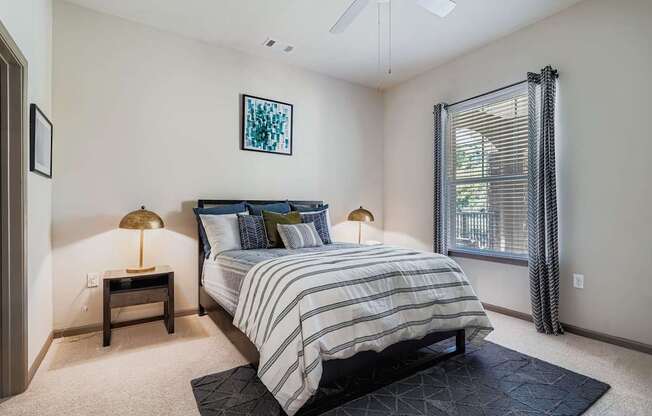 A bedroom with a bed, nightstands, and a ceiling fan.