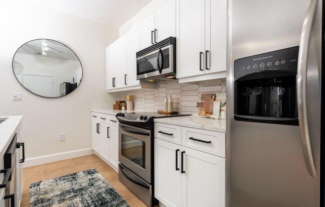 a kitchen with white cabinets and stainless steel appliances