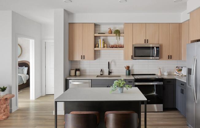 Two-tone cabinetry, open shelving, and a central island create a kitchen designed for gathering and everyday ease.