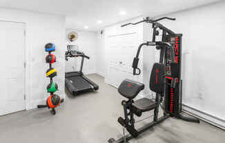 a gym with weights and cardio equipment in a home with white walls