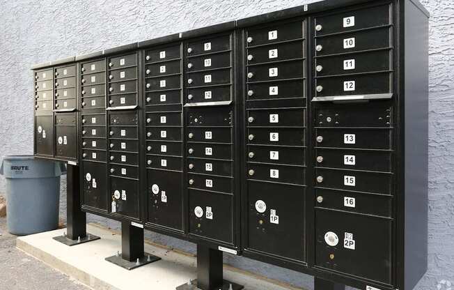 A row of black mailboxes with numbers on them.