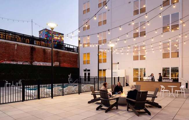 A group of people are sitting around a table on a rooftop.