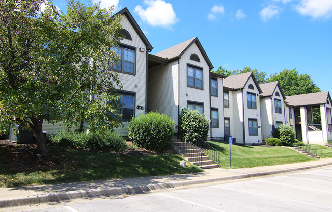 A row of houses with a blue sign in front of the first one.