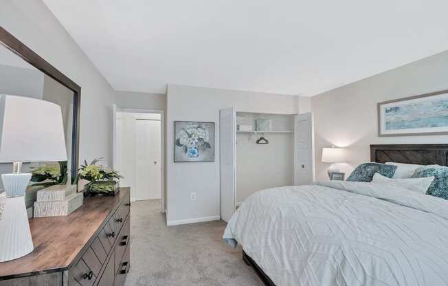 a bedroom with a large bed and a dresser with a mirror