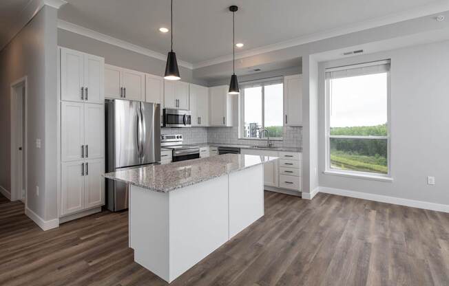 A modern kitchen with a large island and stainless steel appliances.