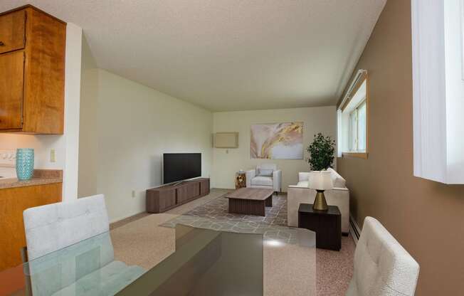 a living room with a glass table and a couch and a tv. Fargo, ND Country Club Apartments.