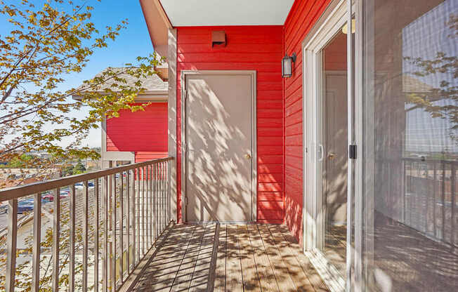 A red house with a white door and a balcony.