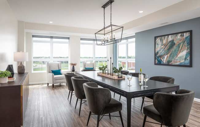 a dining room with a table and chairs and a large window