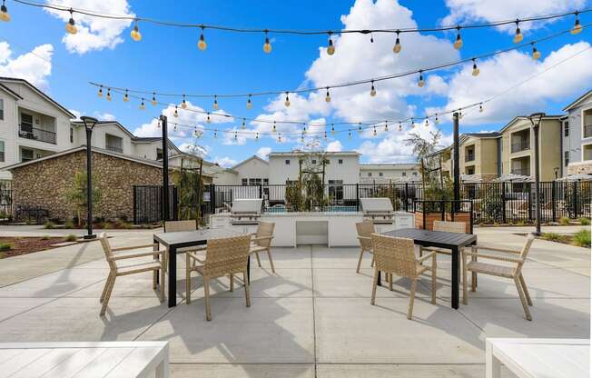 Outdoor seating area overlooking the community BBQ area, Chairs and Hanging Lights at Morgan Ranch Apartments, Morgan Hill