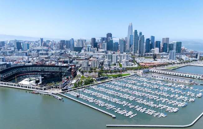 A cityscape with a marina and a stadium.