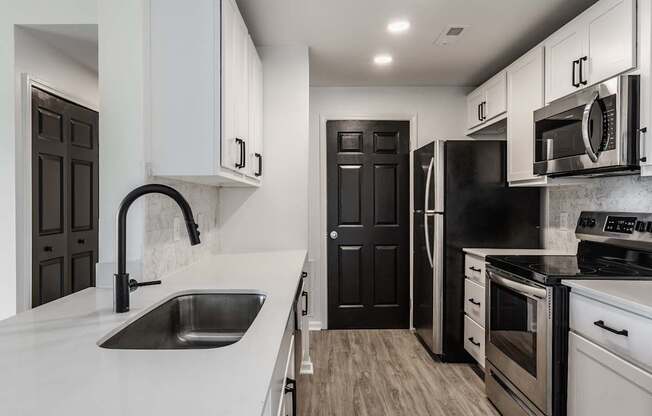 A modern kitchen with black and white appliances and cabinets.
