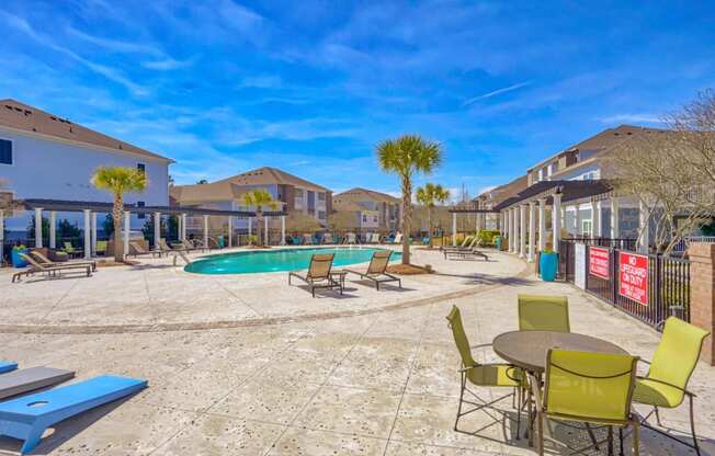 our apartments have a large pool and patio with chairs and tables at Cypress River, Ladson, South Carolina