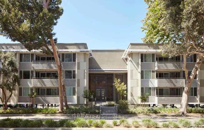 A modern building with a flat roof and a balcony on the second floor.
